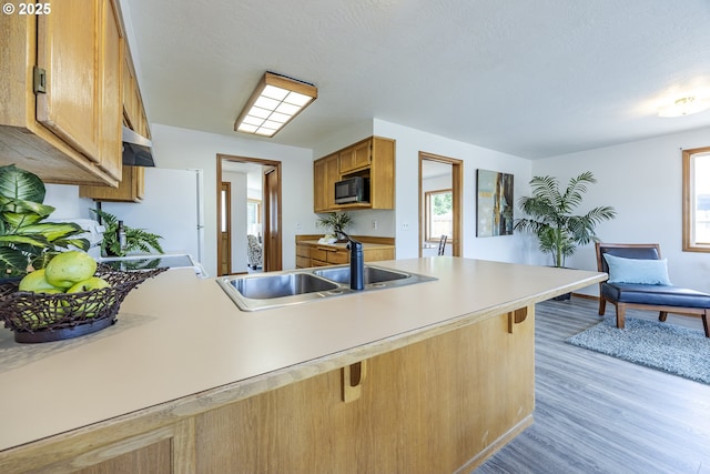 7324 B St, Springfield, OR 97478 - kitchen featuring black microwave, a breakfast bar area, light wood finished floors, a peninsula, and healthy amount of natural light
