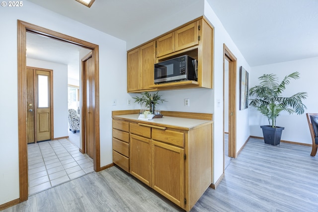 7324 B St, Springfield, OR 97478 - kitchen featuring stainless steel microwave, light wood-type flooring, light countertops, and brown cabinets