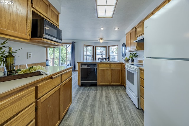 7324 B St, Springfield, OR 97478 - kitchen featuring white appliances, a peninsula, range hood, light wood-style flooring, and brown cabinets