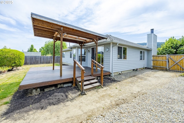 7324 B St, Springfield, OR 97478 - back of property featuring a deck, a fenced backyard, a chimney, and roof with shingles