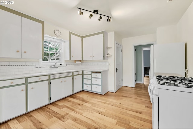 912 Van Buren St, Eugene, OR 97402 - kitchen featuring white appliances, tasteful backsplash, light wood-type flooring, light countertops, and track lighting