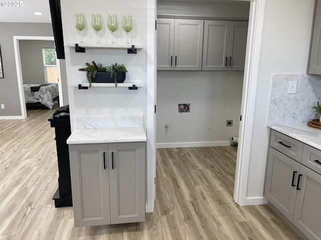 2660 Evergreen Ct, Salem, OR 97301 - laundry area featuring hookup for an electric dryer, cabinet space, washer hookup, light wood-style flooring, and baseboards