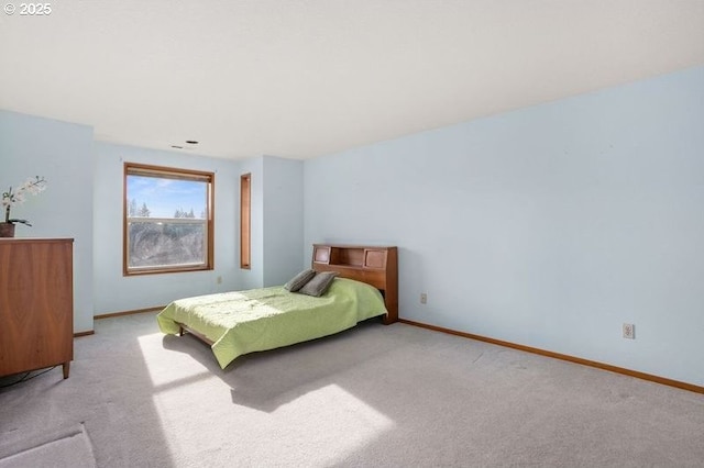 bedroom featuring light colored carpet and baseboards