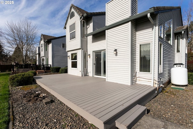 rear view of house featuring a chimney and a deck