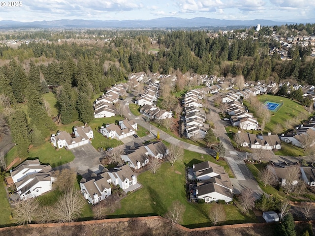 birds eye view of property featuring a residential view, a mountain view, and a view of trees