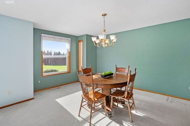 dining room with an inviting chandelier, baseboards, and carpet flooring