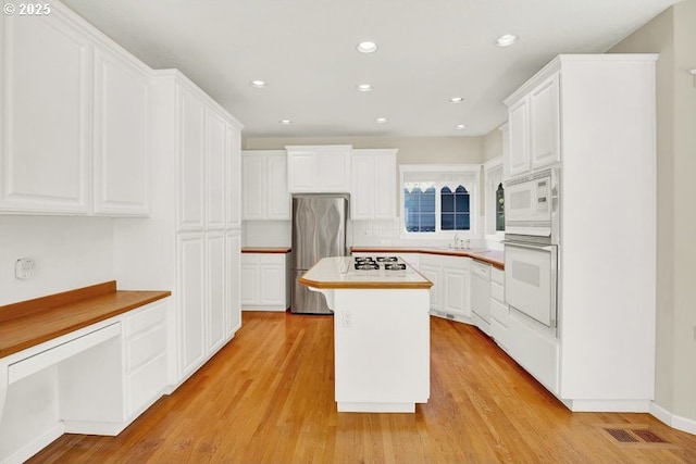 14559 SE Megan Way, Clackamas, OR 97015 - kitchen with white appliances, white cabinetry, light wood-type flooring, a center island, and recessed lighting