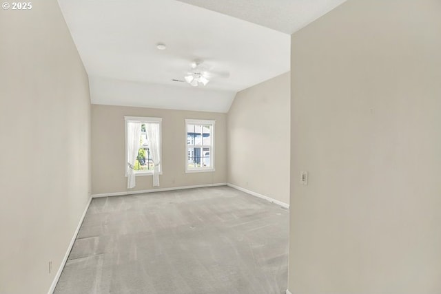 unfurnished room with baseboards, light colored carpet, and lofted ceiling