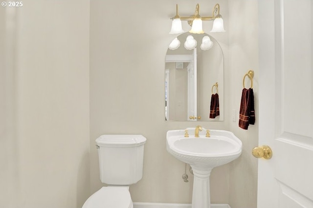 half bathroom with toilet and baseboards