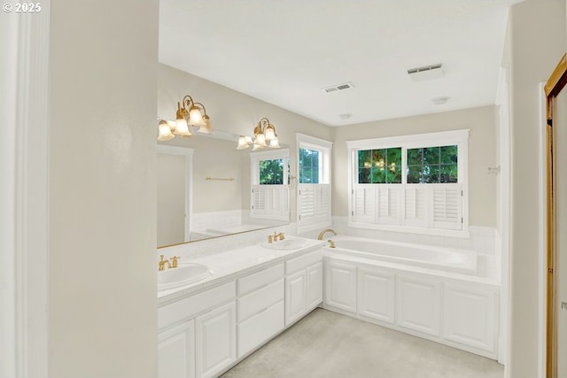 bathroom featuring a chandelier, a bath, and double vanity