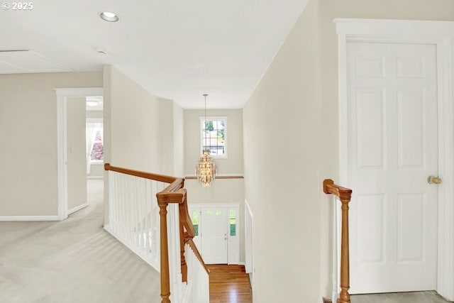 hall featuring an upstairs landing, attic access, baseboards, and recessed lighting