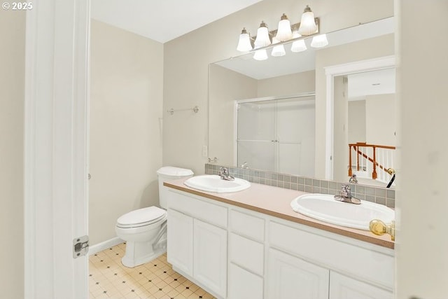 full bath with a stall shower, double vanity, toilet, and tasteful backsplash