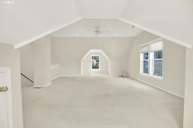 additional living space featuring lofted ceiling, light carpet, baseboards, and a ceiling fan