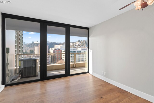 spare room with plenty of natural light, light hardwood / wood-style floors, and expansive windows