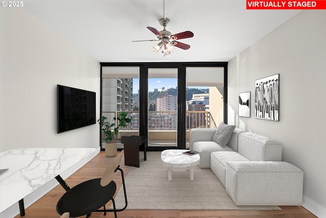 living room with wood-type flooring and ceiling fan