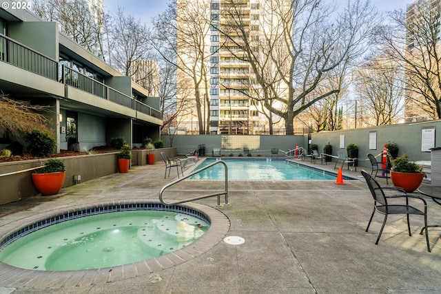 view of swimming pool with a hot tub and a patio area