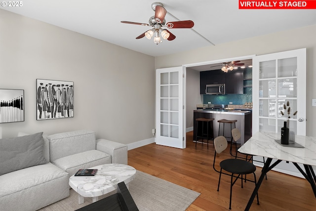 living room with dark wood-type flooring and ceiling fan