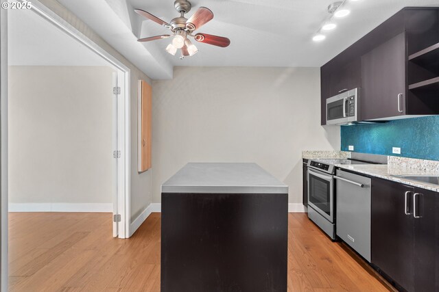 kitchen featuring decorative backsplash, stainless steel appliances, ceiling fan, and light wood-type flooring