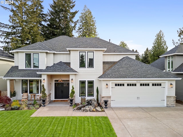 9010 SW Inez St, Tigard, OR 97224 - view of front of property with an attached garage, concrete driveway, a front lawn, stone siding, and a porch