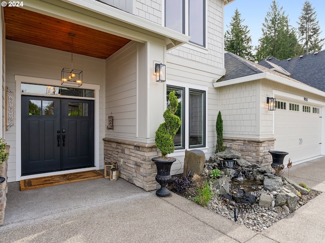 9010 SW Inez St, Tigard, OR 97224 - property entrance with stone siding, roof with shingles, an attached garage, and driveway