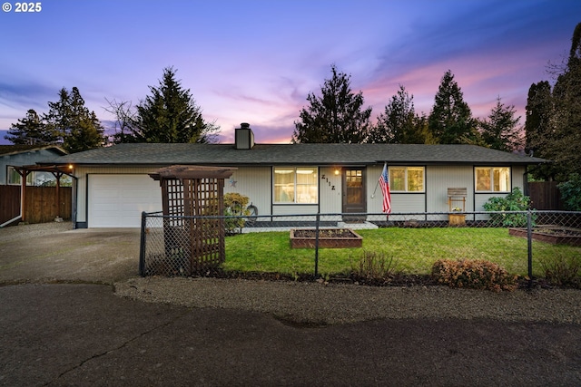 ranch-style home featuring a garage and a lawn