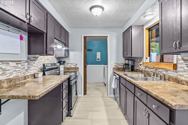 kitchen with sink, dark brown cabinets, stainless steel appliances, washer and dryer, and a textured ceiling