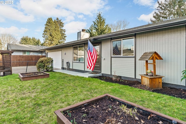 rear view of property featuring a garage and a yard