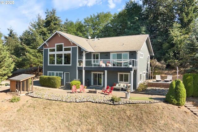 back of house featuring outdoor lounge area, a yard, a patio, and a balcony