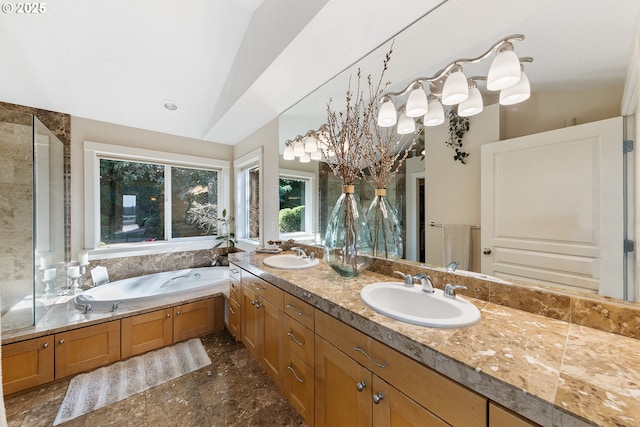 bathroom with vanity, vaulted ceiling, and a bathtub