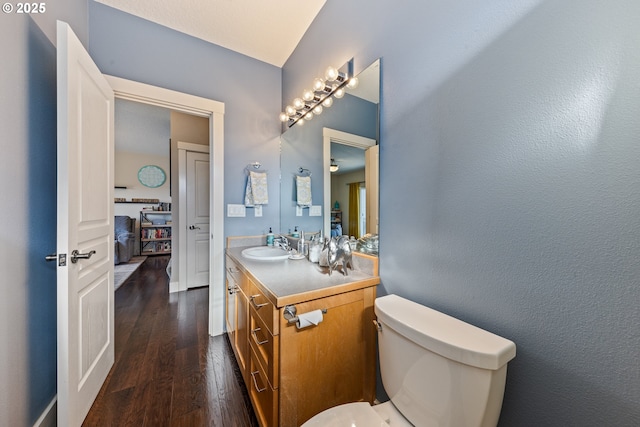 bathroom featuring toilet, vanity, and hardwood / wood-style flooring