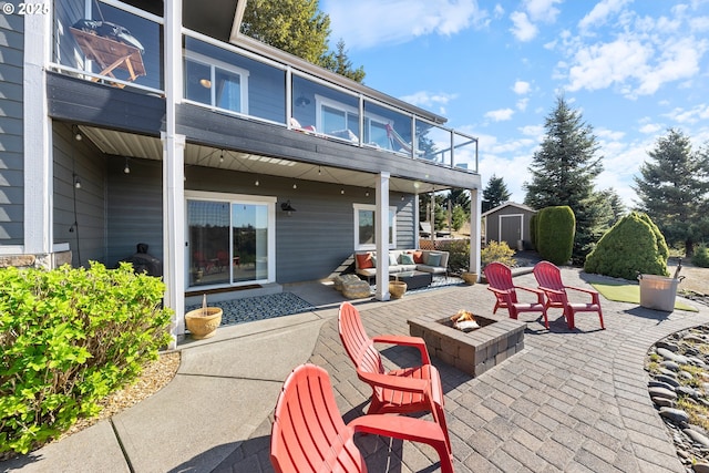 view of patio / terrace featuring a storage unit and an outdoor living space with a fire pit