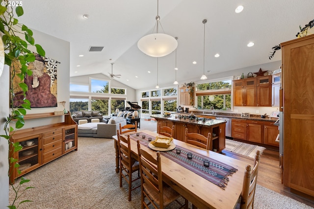 dining room with ceiling fan, sink, high vaulted ceiling, and light hardwood / wood-style flooring