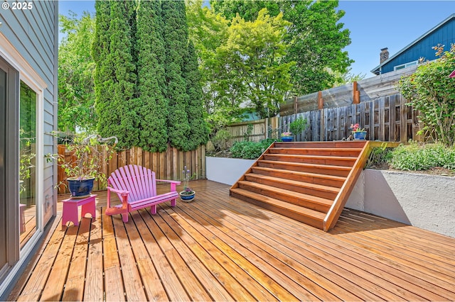 wooden terrace with a fenced backyard
