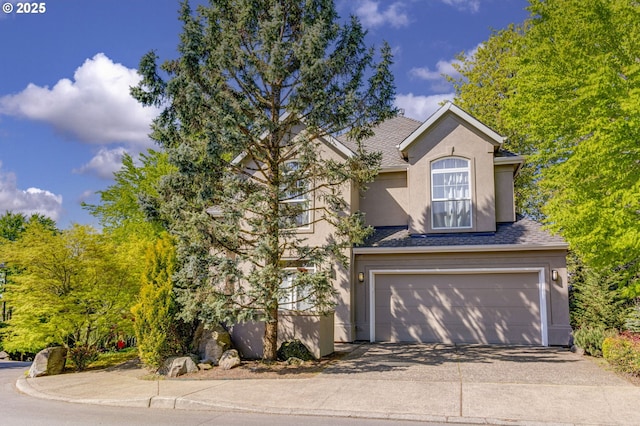 view of front of property featuring stucco siding, concrete driveway, an attached garage, and a shingled roof