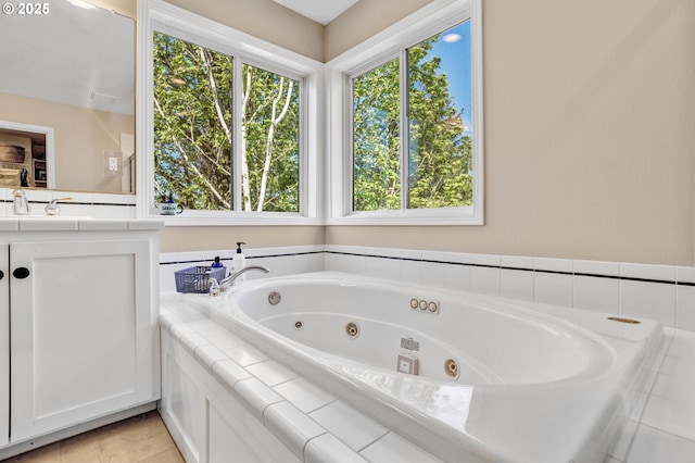 full bathroom featuring a tub with jets, vanity, and tile patterned floors
