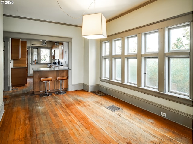 interior space with ornamental molding and dark hardwood / wood-style floors