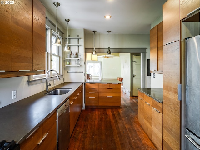 kitchen featuring sink, dark hardwood / wood-style floors, stainless steel appliances, and hanging light fixtures