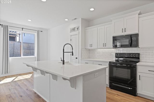 830 NE Buckthorn Dr, Estacada, OR 97023 - kitchen featuring black appliances, a sink, an island with sink, decorative backsplash, and recessed lighting