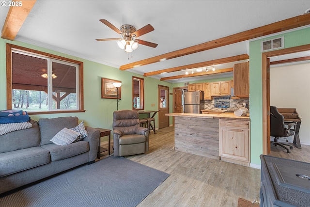 living room featuring light wood-type flooring, ceiling fan, beamed ceiling, an office area, and ornamental molding