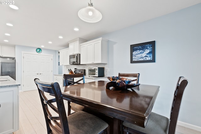 dining space featuring recessed lighting, baseboards, a toaster, and light wood-type flooring