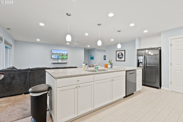 kitchen with open floor plan, recessed lighting, a sink, a kitchen island with sink, and appliances with stainless steel finishes