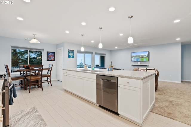 kitchen with recessed lighting, a sink, an island with sink, white cabinets, and appliances with stainless steel finishes