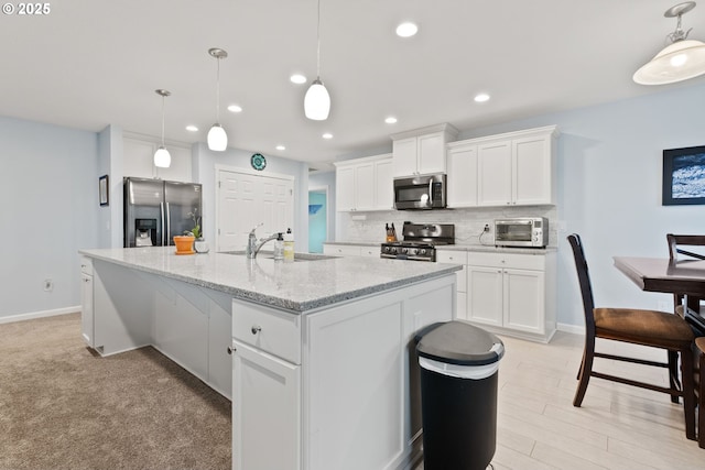 kitchen featuring white cabinetry, a sink, appliances with stainless steel finishes, and decorative backsplash