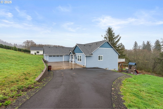 view of front of home with driveway, an attached garage, and a front yard