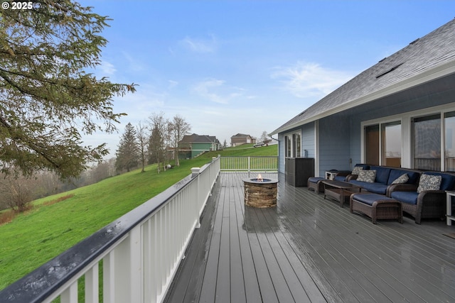 wooden terrace featuring an outdoor living space with a fire pit and a yard