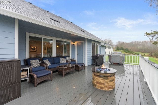 wooden deck featuring area for grilling and an outdoor living space with a fire pit