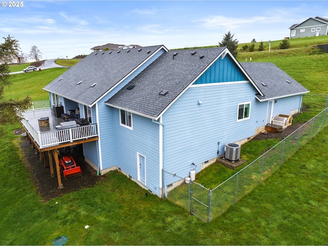 back of house featuring a gate, central air condition unit, a wooden deck, a shingled roof, and a yard