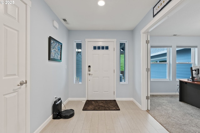 entrance foyer with baseboards, light wood finished floors, and visible vents