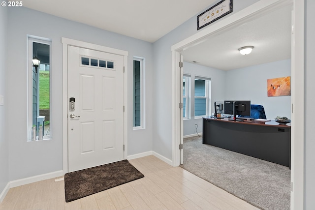 foyer entrance with baseboards and wood finished floors