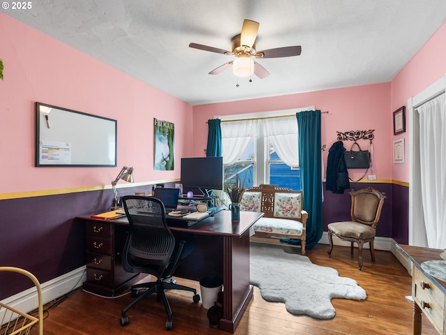 home office featuring hardwood / wood-style flooring, ceiling fan, and a baseboard heating unit